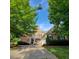 Traditional brick home with a well-manicured lawn, manicured bushes, and a welcoming front porch at 502 Willowmere Ct, Cary, NC 27513