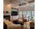 An open living room with hardwood floors, built-in shelving, fireplace, and large sun-filled windows at 502 Willowmere Ct, Cary, NC 27513