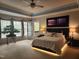 Spacious main bedroom with a decorative tray ceiling, balcony, and a king bed with light accents at 502 Willowmere Ct, Cary, NC 27513