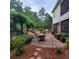 Landscaped backyard with stone patio, comfortable seating, and a wisteria-covered pergola at 502 Willowmere Ct, Cary, NC 27513