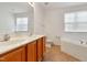 Spacious bathroom featuring a double vanity, a large mirror, and a relaxing soaking tub at 5163 Sandy Banks Rd, Raleigh, NC 27616