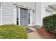Stylish gray front door with sidelights and a welcome mat, surrounded by green bushes at 5163 Sandy Banks Rd, Raleigh, NC 27616