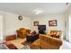 Bright living room featuring comfortable armchairs, a TV, and elegant wall decor at 5163 Sandy Banks Rd, Raleigh, NC 27616