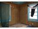 Bedroom with wood paneling, two windows, and a worn carpet at 537 Homeland Ave, Durham, NC 27707