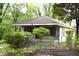 Side view of a home with a covered porch and overgrown landscaping at 537 Homeland Ave, Durham, NC 27707