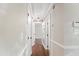A well-lit hallway with wood floors leads to other rooms in the home at 5500 Fortunes Ridge Dr # 72A, Durham, NC 27713