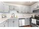 This updated kitchen features grey cabinetry, stainless appliances, subway tile backsplash and quartz countertops at 5500 Fortunes Ridge Dr # 72A, Durham, NC 27713