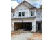 New construction home featuring a two-car garage and visible framework under Kingspan GreenGuard building wrap at 6002 Shade Tree Ln, Durham, NC 27703