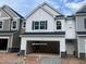 New construction two-story townhome with two-car garage and white siding and black shutters at 6002 Shade Tree Ln, Durham, NC 27703