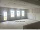 Unfinished great room featuring drywall, large windows, and open-concept layout at 6002 Shade Tree Ln, Durham, NC 27703