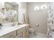 Bright bathroom with floral shower curtain, marble sink, and window view at 667 Ashley Woods Dr, Gibsonville, NC 27249