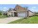 Charming home featuring a two-car garage, stone accents, covered entryway, and driveway at 667 Ashley Woods Dr, Gibsonville, NC 27249