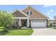 Charming home featuring a two-car garage, stone accents, covered entryway, and manicured lawn at 667 Ashley Woods Dr, Gibsonville, NC 27249