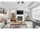 Cozy living room boasts a fireplace, ceiling fan, and a large window for ample natural light at 667 Ashley Woods Dr, Gibsonville, NC 27249