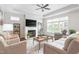 Bright living room features a fireplace, tray ceiling, a ceiling fan, and neutral decor at 667 Ashley Woods Dr, Gibsonville, NC 27249