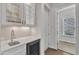 Stylish bar area with wine storage, sink, glass shelving, and marble countertop at 8121 Greys Landing Way, Raleigh, NC 27615