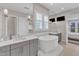 Bright bathroom featuring double vanity, soaking tub, large mirror, and access to bedroom at 8121 Greys Landing Way, Raleigh, NC 27615