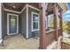 Inviting covered front porch with stone floor, wood columns, and comfortable seating creating a welcoming entry at 8121 Greys Landing Way, Raleigh, NC 27615