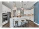 Modern kitchen with a large island, white cabinetry, stainless steel appliances, and elegant pendant lighting at 8121 Greys Landing Way, Raleigh, NC 27615