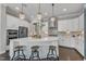 Stunning kitchen featuring white cabinets, modern appliances, a spacious island, and sleek pendant lights at 8121 Greys Landing Way, Raleigh, NC 27615