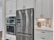 Modern kitchen featuring stainless steel appliances, white cabinetry, and elegant countertops at 8121 Greys Landing Way, Raleigh, NC 27615
