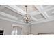 A beautiful crystal chandelier hangs from a coffered ceiling in this luxurious home at 8121 Greys Landing Way, Raleigh, NC 27615