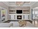 Bright living room with fireplace, built-in shelving, and doors to the outside at 8121 Greys Landing Way, Raleigh, NC 27615