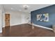 Spacious living room featuring hardwood floors, a dark accent wall, and unique sliding barn door at 8121 Greys Landing Way, Raleigh, NC 27615