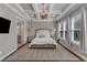Comfortable main bedroom with coffered ceilings, chandelier, and ensuite access at 8121 Greys Landing Way, Raleigh, NC 27615