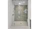 Luxurious glass shower enclosure with mosaic tile surround and modern shower head at 8121 Greys Landing Way, Raleigh, NC 27615