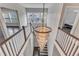 Staircase featuring modern chandelier lighting, wooden railing, and steps with dark hardwood flooring at 8121 Greys Landing Way, Raleigh, NC 27615