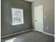 An empty bedroom with neutral walls, a window offering natural light, and modern light grey flooring at 825 Long Ave, Rocky Mount, NC 27801
