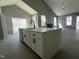 Kitchen island with white countertop, black faucet and modern black cabinet pulls under high vaulted ceilings at 825 Long Ave, Rocky Mount, NC 27801