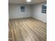 Bedroom with wood-look floors, neutral paint, and two windows for ample natural light at 905 Ardmore Dr, Durham, NC 27713