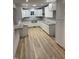 Modern kitchen with white cabinets, granite countertops, stainless steel sink and wood-look floors at 905 Ardmore Dr, Durham, NC 27713