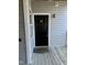Entrance to unit 201 featuring a black door, gold numbers, and a 'Home' welcome mat at 1140 Carlton Ave # 201, Raleigh, NC 27606
