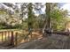 Back deck with grill overlooking the backyard with mature trees and a small garden at 1203 Brookside Dr, Raleigh, NC 27604