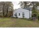 Charming single-story home featuring light siding, windows and a mailbox surrounded by lush greenery and trees at 1203 Brookside Dr, Raleigh, NC 27604