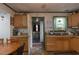 Functional kitchen with wooden cabinets, and a view into an adjacent laundry room with a washer and dryer at 1203 Brookside Dr, Raleigh, NC 27604