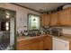 Functional kitchen area features wooden cabinets, an undermount sink, and a door to an adjacent space at 1203 Brookside Dr, Raleigh, NC 27604