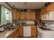 Traditional kitchen featuring wood cabinets, laminate countertops, and a window with floral curtains at 1203 Brookside Dr, Raleigh, NC 27604