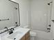 Clean bathroom featuring white tub and walls, a wooden vanity, and black hardware at 124 Horseman Dr, Louisburg, NC 27549