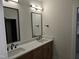 Bathroom featuring double sink vanity, quartz countertops, dark faucets, and modern mirrors at 124 Horseman Dr, Louisburg, NC 27549