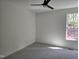 Neutral-toned bedroom with ceiling fan, carpeted floor, and window bringing in ample natural light at 124 Horseman Dr, Louisburg, NC 27549