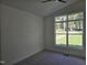Bright bedroom featuring a large window offering scenic outside views and carpeted flooring at 124 Horseman Dr, Louisburg, NC 27549