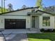 Charming home with black garage door, modern architectural features, and well-manicured lawn at 124 Horseman Dr, Louisburg, NC 27549