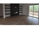 Living room featuring sleek fireplace, floating shelves, wood flooring, and sliding doors to the deck at 124 Horseman Dr, Louisburg, NC 27549