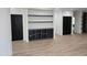 Open living room with built in shelving, gray accent walls, and wooden floors, ready for personalization at 124 Horseman Dr, Louisburg, NC 27549