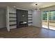 Open living room with fireplace, hardwood floors, custom shelving, and access to a wooden deck at 124 Horseman Dr, Louisburg, NC 27549