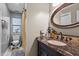 Bathroom boasts a granite vanity with decorative mirror, matching fixtures, and a shower behind a curtain at 130 E Longview St # Apt K, Chapel Hill, NC 27516